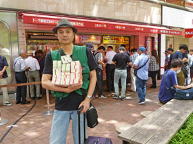 西銀座チャンスセンターの売り場の前で今日買ったサマージャンボ宝くじを抱えて記念撮影