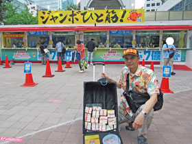 大阪駅前第4ビル特設売場の前で今日買ったサマージャンボ宝くじをバックに詰めて記念撮影