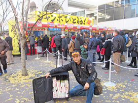 大阪駅前第四ビル特設売場の前で今日買った年末ジャンボ宝くじをバックに詰めて記念撮影